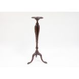 A mahogany torchere with triple carved slatted tulip shaped column on a tripod base with claw and