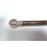 A golf umbrella, the silver handle of golf ball form containing a scoring pencil, retailed by Brigg,