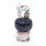 A Japanese porcelain incense burner, the cover with a lion and ball finial,