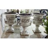 Three cast iron campana shaped two-handled vases with Tudor rose and scrolls in relief on pedestal