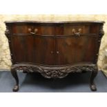 A fine English 19th century flame mahogany serpentine shaped commode having carved decoration and