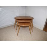 An Ercol pale elm “pebble” nest of three tables.