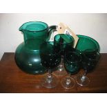 A collection of green glass ware, the jug 16 cm high