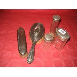 Three silver topped dressing table jars, a silver topped brush together with another (5)