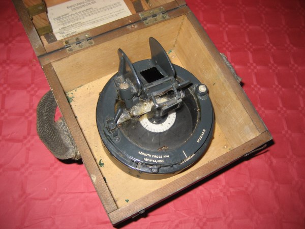 A cased military compass together with accompanying stand etc (3)