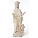 STATUETTE FEMININE EN TERRE CUITE
GRECE, CIRCA VEME SIECLE AVANT J.C.
Debout sur une base