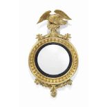 A REGENCY GILTWOOD CONVEX MIRROR
EARLY 19TH CENTURY
With eagle crest and foliate apron, plate