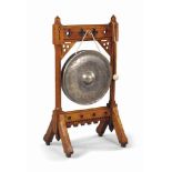 A VICTORIAN GOTHIC OAK GONG
LATE 19TH CENTURY, IN THE MANNER OF HOWARD AND SONS
With a brass gong