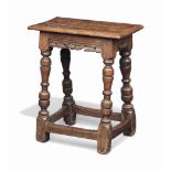 A CHARLES II OAK JOINED STOOL
MID 17TH CENTURY
With associated top above scroll friezes and baluster