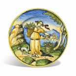 A SMALL ITALIAN MAIOLICA PLATE
CIRCA 1560, VENICE OR URBINO
Painted with a lady carrying a basket of