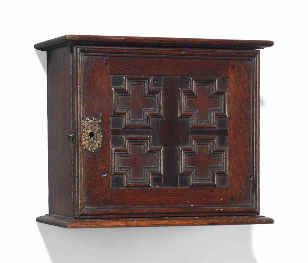 AN ENGLISH OAK SPICE CABINET
EARLY 18TH CENTURY
Carved with a moulded panelled front hinged to