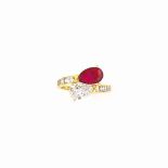 A RUBY AND DIAMOND TWO STONE RING
Of crossover design set with a pear-shaped ruby and a pear-