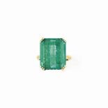 AN EMERALD SINGLE-STONE RING
The rectangular cut-cornered emerald, claw-set to a pierced,