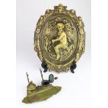 (Lot of 2) Oval brass relief plaque, with putti and scalloped border, framing a reserve of tulips