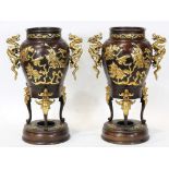 Pair of Chinese patinated bronze and gilt decorated vases, each having dragon form handles, above