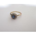 An unmarked but tested to at least 9ct gold ring set with diamonds and central sapphire