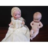 A small sized AM 341 dream baby doll together with Heuback baby figurine