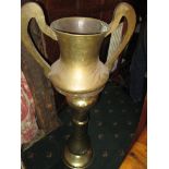 A brass jardinere stand, the pot in the form of a twin handled vase