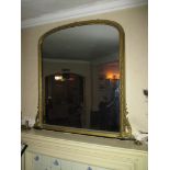 A large gilt plaster framed over mantle mirror