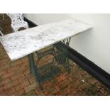 A singer sewing machine table bottom with a marble top