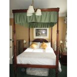 An antique and later four poster bed with green canopy