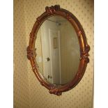 A modern oval, gilt framed wall mirror