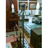20th Century wrought iron two branch floor standing candle stand, raised on scroll tripod base