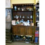 1920's period oak dresser having plate rack, the base fitted two linen fold carved panel doors above