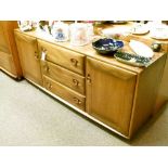 Ercol 'Golden Dawn' elm sideboard fitted three central drawers flanked each side by a door