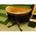 Victorian figured walnut demi-lune fold-over card table standing on a carved and turned pillar and