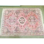 Modern Middle Eastern rug decorated with three central medallions on a pink ground within multi