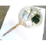 Early 20th Century brass hand mirror, the circular bevelled plate housed within an ornate Indian