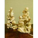 Two late 19th/early 20th Century Japanese ivory okimono, each depicting a man with children