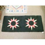 1960's period rectangular rug depicting two orange and yellow stars against a black ground