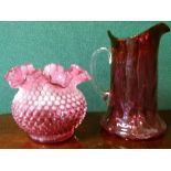 Pink vaseline glass vase having a ruffled rim together with a pink glass jug with a clear handle