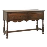 George III oak low dresser fitted two short drawers, shaped apron below and standing on turned