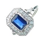 Sapphire and diamond panel ring, the rectangular cut corner stone enclosed by eighteen brilliant