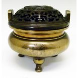 Chinese silver inlaid bronze tripod censer having a pierced and carved hardwood cover and with