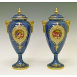 Pair of Royal Worcester urn shaped vases and covers by William Bee, each having a circular reserve