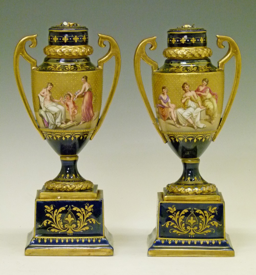 Pair of late 19th Century Vienna style porcelain two handled urn shaped vases, each having painted