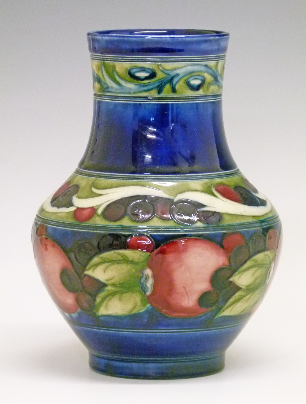 William Moorcroft baluster vase decorated with a banded Pomegranate pattern on a blue ground, base