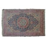 Middle Eastern rug decorated with a central medallion on a blue and fawn ground within multi