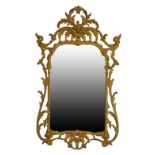 Rococo style carved giltwood framed wall mirror having typical pierced and scroll decoration,