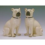Pair of 19th Century Staffordshire cream glazed pottery figures of seated Pugs, 28cm high