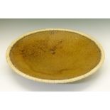 Large studio pottery shallow bowl having an incised mottled brown glaze, plaited rush border and