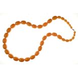 Row of graduated amber beads, the thirty-eight barrel shaped beads, 1cm long to 2.4cm long,