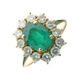 Emerald and diamond cluster ring, stamped'750', the oval cut measuring approximately 8.7mm x 6.6mm