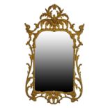 Rococo style carved giltwood framed wall mirror having typical pierced and scroll decoration,