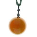 Amber pendant of almost hemispherical form, 5.4cm diameter, 2cm deep, on a cord necklace, 36g gross