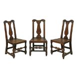 Three 18th Century oak hard seat side chairs, each having a vase shaped back splat and standing on